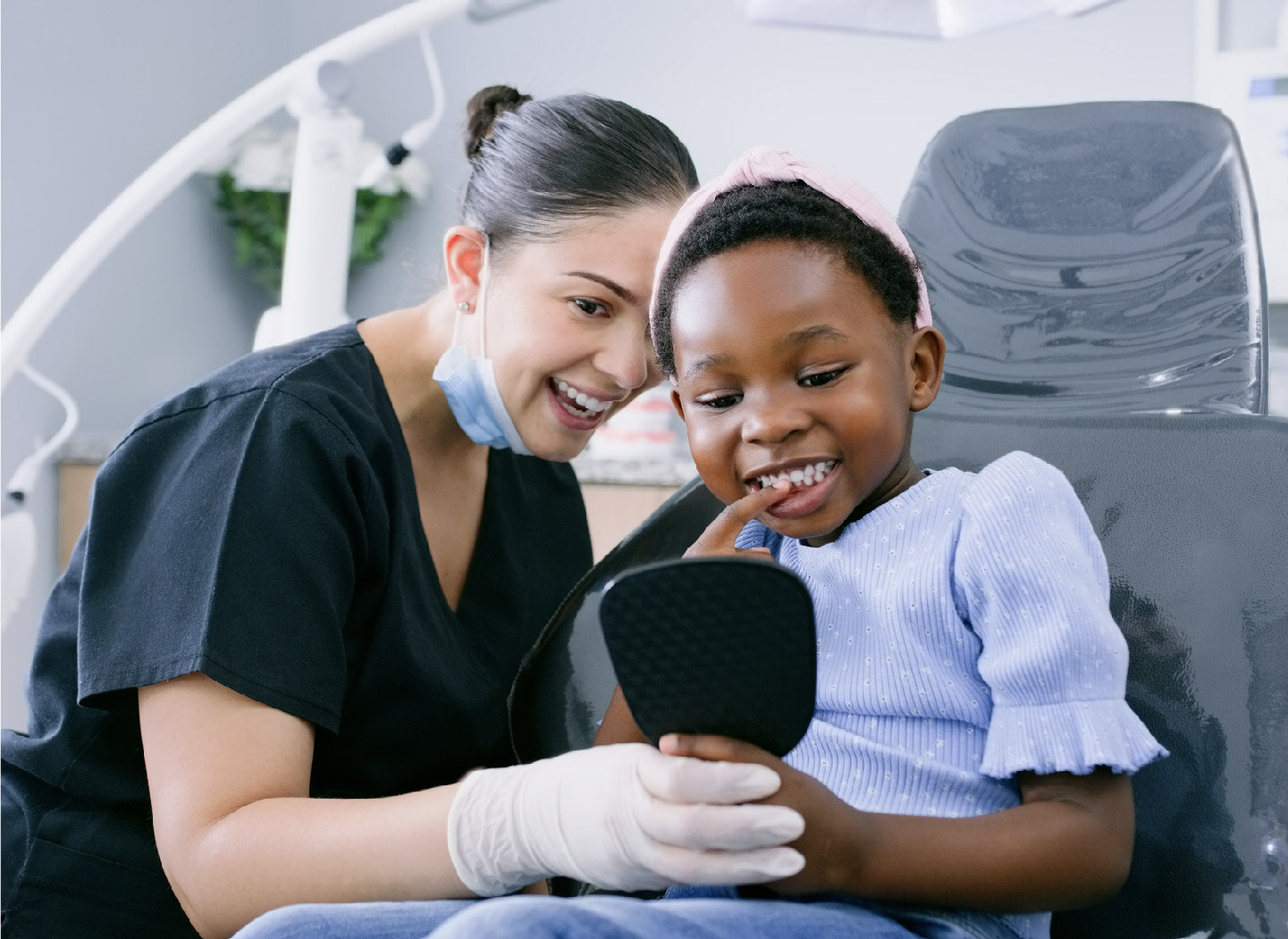 dental professional holds a mirror for the patient to look at his teeth